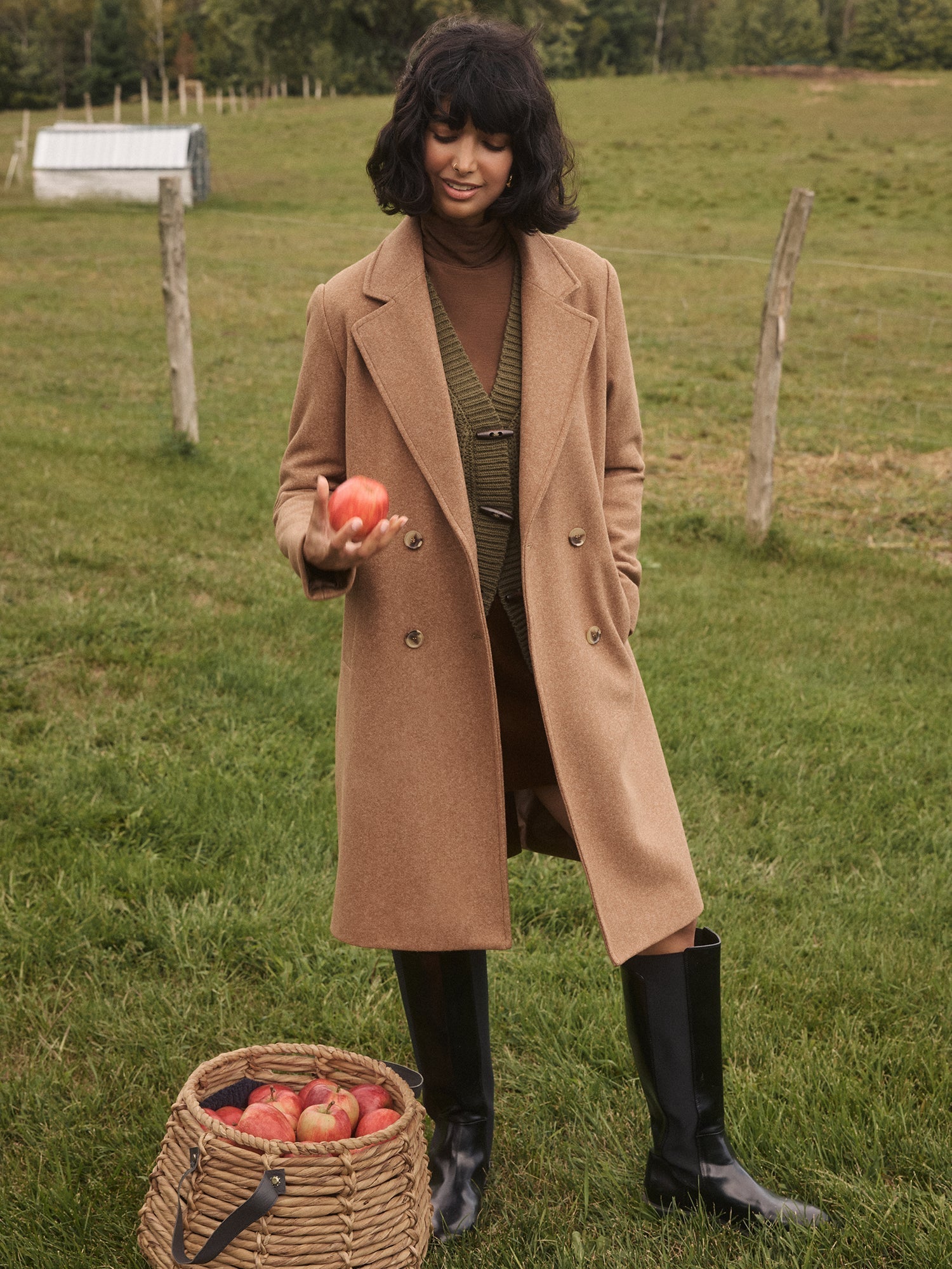 Women Holding an Apple in a Double-Breasted Mid-Length Coat