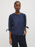 Button-front blouse in snow white with tie cuffs and pleated sleeves by Suzy Shier.