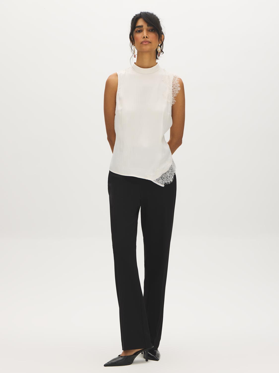 Winter White Sleeveless Mock Neck Blouse with Lace Inserts - Woman Wearing Asymmetrical Hem Top - Suzy Shier