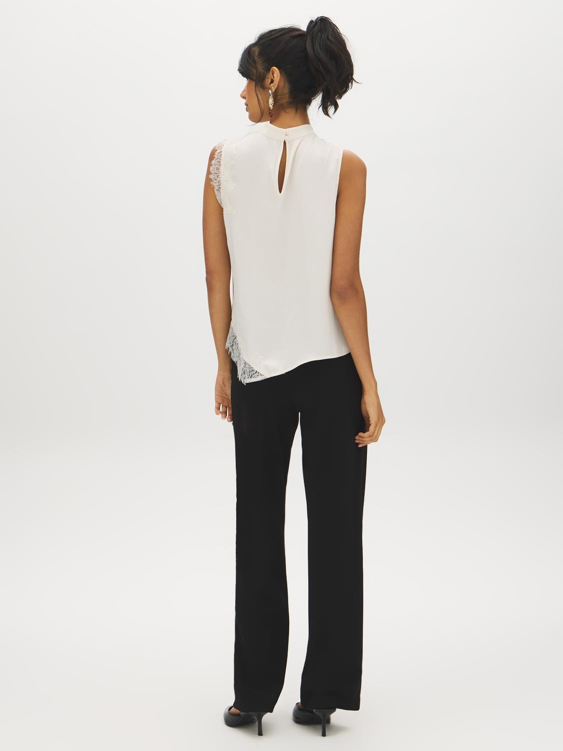 Winter White Sleeveless Mock Neck Blouse with Lace Inserts - Woman Wearing Asymmetrical Hem Top - Suzy Shier