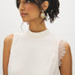 Winter White Sleeveless Mock Neck Blouse with Lace Inserts - Woman Wearing Asymmetrical Hem Top - Suzy Shier