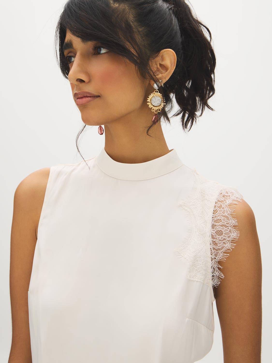 Winter White Sleeveless Mock Neck Blouse with Lace Inserts - Woman Wearing Asymmetrical Hem Top - Suzy Shier