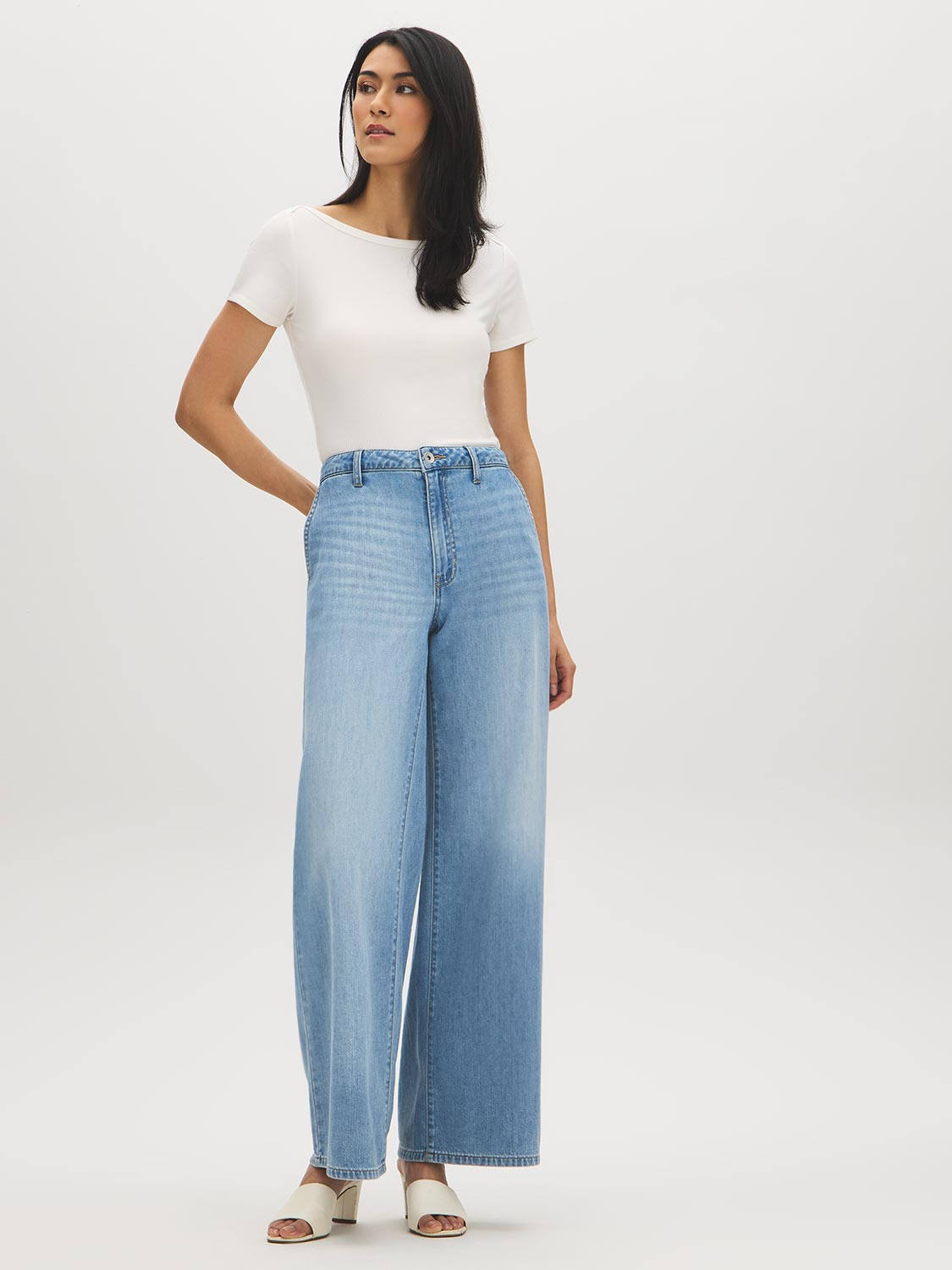 White fitted cap-sleeve T-shirt with a short sleeve line over wide-leg jeans