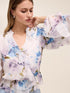 Floral peplum blouse with ruffle details and elasticized waist by Le Chateau.
