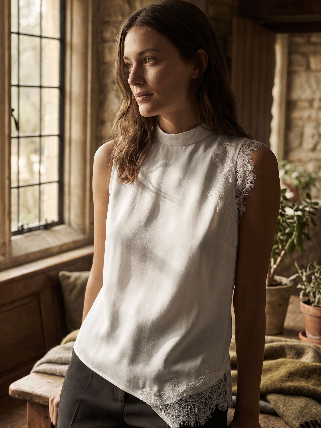 Winter White Sleeveless Mock Neck Blouse with Lace Inserts - Woman Wearing Asymmetrical Hem Top - Suzy Shier