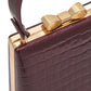 Black/Gold Faux Leather Croc Minaudire with Jewel Bow - Close-up Clasp Detail - Le Chateau
