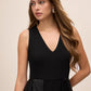 Black V-Neck Jumpsuit with Jacquard Skirt Overlay - Close-up V-Neckline Detail - Le Chateau
